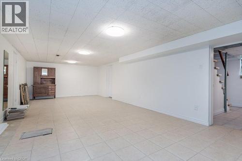 Spacious open-concept room featuring light-toned tile flooring, recessed overhead lighting, and crisp white walls - 139 Mackay Crescent, Waterloo, ON 
