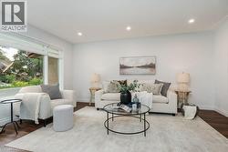 Bright living area featuring recessed lighting, dark wood-finish flooring, and white baseboards - 