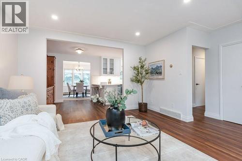 Open-concept living area featuring rich wood-finish flooring, recessed lighting, and crisp white walls - 139 Mackay Crescent, Waterloo, ON - Indoor Photo Showing Living Room