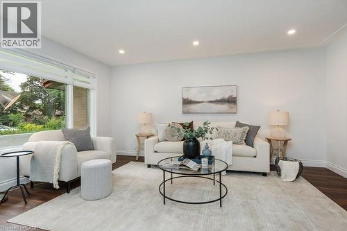 Bright living area featuring recessed lighting, dark wood-finish flooring, and white baseboards - 139 Mackay Crescent, Waterloo, ON 