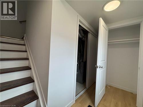 Hardwood stair treads with a white painted riser, neutral wall paint, light wood-finish flooring, and a white recessed ceiling light fixture - 113 Highriver Trail Unit# Main, Welland, ON - Indoor Photo Showing Other Room