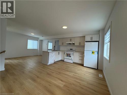 Open-concept kitchen and living area featuring wood-finish flooring, recessed lighting, and ample natural light from multiple windows - 113 Highriver Trail Unit# Main, Welland, ON - Indoor Photo Showing Kitchen