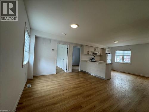 Open-concept living area featuring wood-finish flooring, recessed lighting, and white walls - 113 Highriver Trail Unit# Main, Welland, ON - Indoor