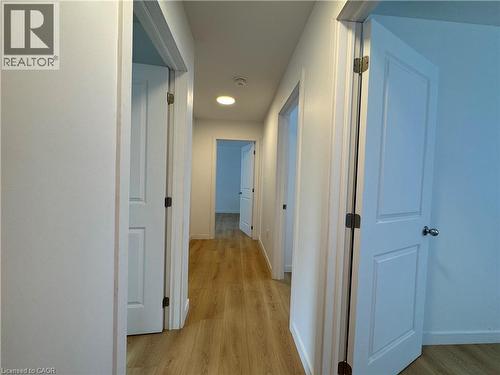 Hallway featuring wood-finish flooring, recessed lighting, white walls, and white paneled doors with chrome hardware - 113 Highriver Trail Unit# Main, Welland, ON - Indoor Photo Showing Other Room
