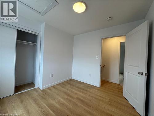 Room featuring wood-finish flooring, white walls, and a built-in closet with sliding doors - 113 Highriver Trail Unit# Main, Welland, ON - Indoor Photo Showing Other Room