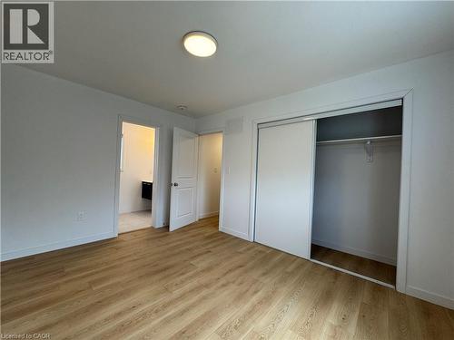 Spacious room featuring wood-finish flooring, white walls, and a ceiling-mounted light fixture - 113 Highriver Trail Unit# Main, Welland, ON - Indoor Photo Showing Other Room