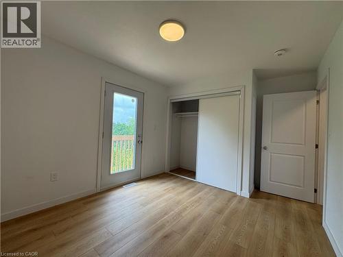 Interior room featuring wood-finish flooring, white walls, and a flush mount ceiling light - 113 Highriver Trail Unit# Main, Welland, ON - Indoor Photo Showing Other Room