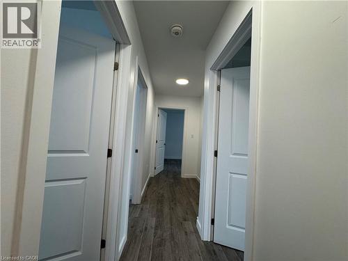 Hallway featuring wood-finish flooring, recessed lighting, and multiple white paneled doors - 119 Highriver Trail Unit# Main, Welland, ON - Indoor Photo Showing Other Room