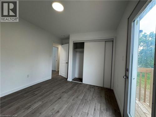 Room featuring wood-finish flooring, recessed lighting, white walls, a sliding glass door to an exterior deck, and a closet with sliding panel doors - 119 Highriver Trail Unit# Main, Welland, ON - Indoor Photo Showing Other Room
