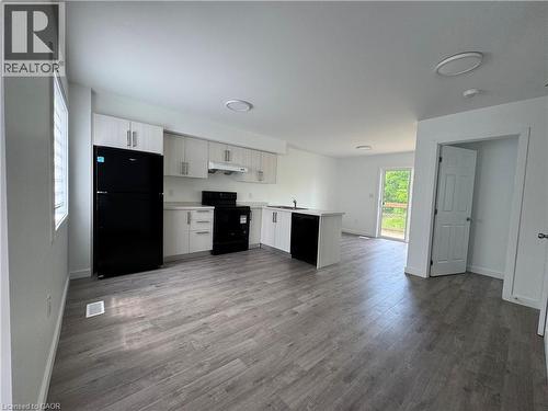 Open-concept kitchen and living area featuring wood-finish flooring - 133 Highriver Trail Unit# Main, Welland, ON 