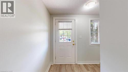Entryway featuring a white paneled door with a glass insert, wood-finish flooring, and a flush-mount ceiling light - 980 Creekside Drive, Waterloo, ON - Indoor Photo Showing Other Room
