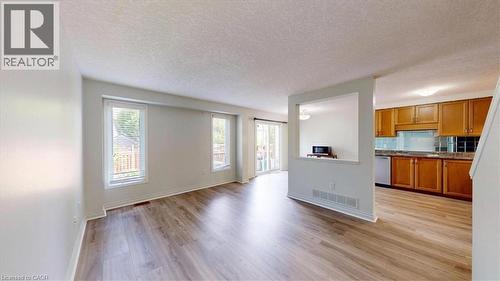 Spacious interior featuring wood-finish flooring, multiple windows, and a sliding glass door providing access to the exterior - 980 Creekside Drive, Waterloo, ON - Indoor Photo Showing Kitchen