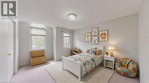 Bright bedroom with two windows, including an arched transom window, providing natural illumination - Virtually staged - 980 Creekside Drive, Waterloo, ON - Indoor Photo Showing Bedroom