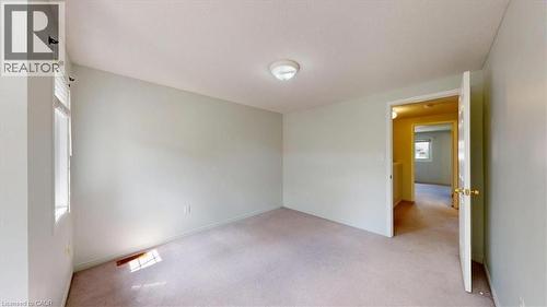 Carpeted room featuring a single window with blinds and a flush mount light fixture - 980 Creekside Drive, Waterloo, ON - Indoor Photo Showing Other Room