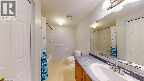 Full bathroom featuring a single vanity with an integrated sink, a rectangular mirror, and a shower-over-tub combination with tiled surround - 980 Creekside Drive, Waterloo, ON - Indoor Photo Showing Bathroom