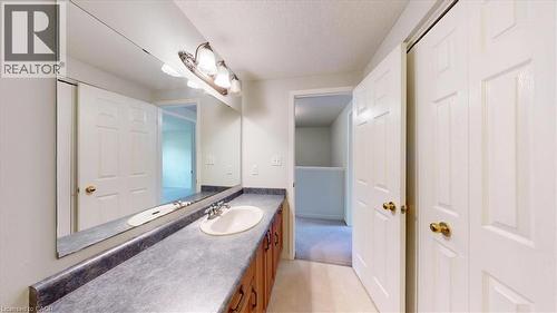 Vanity with integrated sink, laminate countertop, and wood-finish cabinetry - 980 Creekside Drive, Waterloo, ON - Indoor Photo Showing Bathroom
