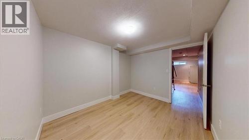 Room featuring wood-finish flooring, a flush-mount ceiling light, and a white baseboard trim - 980 Creekside Drive, Waterloo, ON - Indoor Photo Showing Other Room
