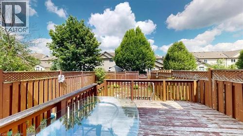 Wood deck with slatted railing and privacy lattice, featuring a backyard space with mature trees - 980 Creekside Drive, Waterloo, ON - Outdoor With Deck Patio Veranda