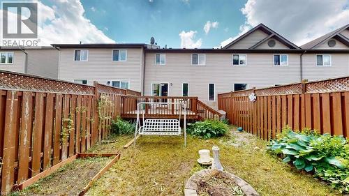 Private backyard featuring a wooden deck with railing, surrounded by a tall wood privacy fence - 980 Creekside Drive, Waterloo, ON - Outdoor With Deck Patio Veranda With Exterior