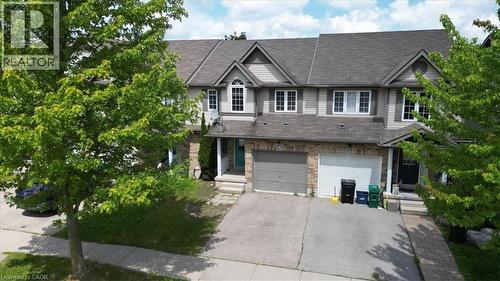 Modern residential townhouse featuring a light-colored siding exterior with a stone accent facade - 980 Creekside Drive, Waterloo, ON - Outdoor With Facade
