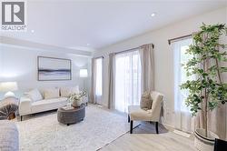 Bright living area featuring wood-finish flooring, recessed lighting, and white baseboards - 