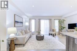 Bright living area featuring wood-finish flooring, recessed lighting, and sheer window treatments - 