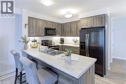 Kitchen featuring wood-grain cabinetry, light-toned countertops, and stainless-steel appliances - 