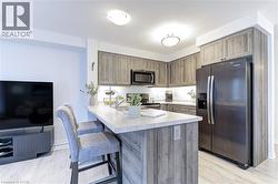 Kitchen featuring wood-finish cabinetry, light-toned countertops, and stainless steel appliances - 