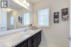 Bathroom vanity featuring an integrated sink, laminate countertop, and wood-finish cabinetry - 