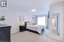 Spacious bedroom with light-colored carpeting, white walls, and crown molding - 