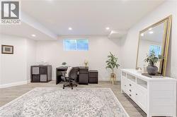 Spacious room featuring wood-finish flooring, recessed lighting, and a window with horizontal blinds - 