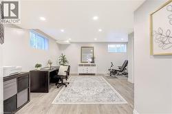 Spacious room featuring wood-finish flooring, recessed lighting, and white walls - 