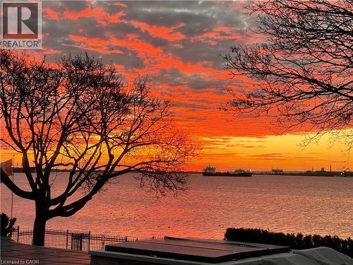 Waterfront scenery featuring a vibrant sunset, mature trees, and marine activity - 90 Oaklands Park Court, Burlington, ON - Outdoor With Body Of Water With View