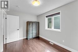 Room featuring rich wood-finish flooring and light-toned walls - 