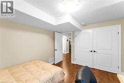 Interior room featuring wood-finish flooring, light neutral-toned walls, and white trim - 
