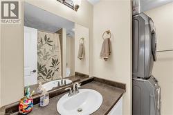 Bathroom vanity with integrated sink, dark countertop, and large wall-mounted mirror - 