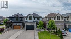 Contemporary two-story residence featuring a light blue exterior with stone accents and a dark roof - 