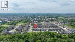 Aerial perspective showcasing the residential neighborhood with a dense tree line - 