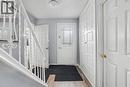 Entryway featuring wood-finish flooring, a white paneled front door with decorative glass inserts, and an iron baluster staircase - 47 Bowman Street, Hamilton, ON 