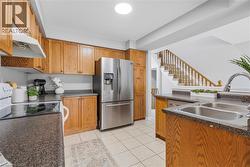 Kitchen with wood cabinetry, dark countertops, and stainless steel appliances - 