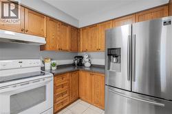 Well-appointed kitchen featuring wood cabinetry with dark countertops - 