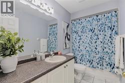 Bathroom vanity featuring an integrated sink, speckled countertop, and white cabinetry - 