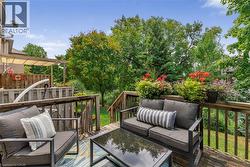 Multi-level wood deck featuring a pergola, wood privacy fencing, and mature trees surrounding the property - 