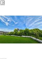 Expansive outdoor area featuring artificial turf, a black chain-link fence, and concrete block retaining walls - 