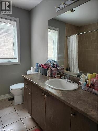 Bathroom featuring a vanity with an integrated sink, laminate countertop, and wood-finish cabinetry - 249 Bussel Crescent, Milton, ON 