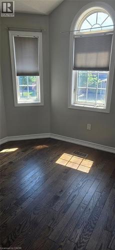 Rich wood-finish flooring provides a striking contrast to light grey walls - 249 Bussel Crescent, Milton, ON 