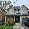 Traditional-style two-story home featuring a brick and stucco facade, an attached garage, and a covered front porch with stone-clad columns - 249 Bussel Crescent, Milton, ON 