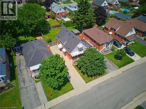 Brick residential property with a dark shingle roof and front awnings - 282 East 13Th Street, Hamilton, ON 