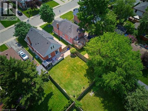 Aerial view featuring multiple residential properties with established lawns, mature trees, concrete driveways, and paved street access - 282 East 13Th Street, Hamilton, ON 