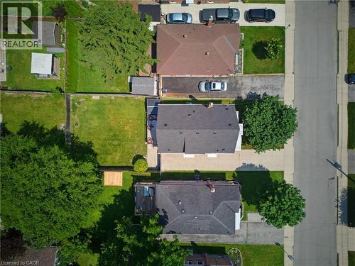 Aerial view featuring multiple residential properties with established lawns, mature trees, concrete driveways, and paved street access - 282 East 13Th Street, Hamilton, ON 